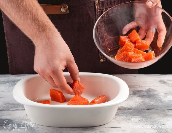 См<span>ажьте форму для запекания растительным маслом. Выложите куски рыбы.</span>