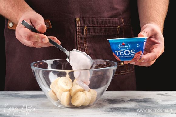 Выложите в миску бананы и греческий йогурт «TEOS» с клубникой.