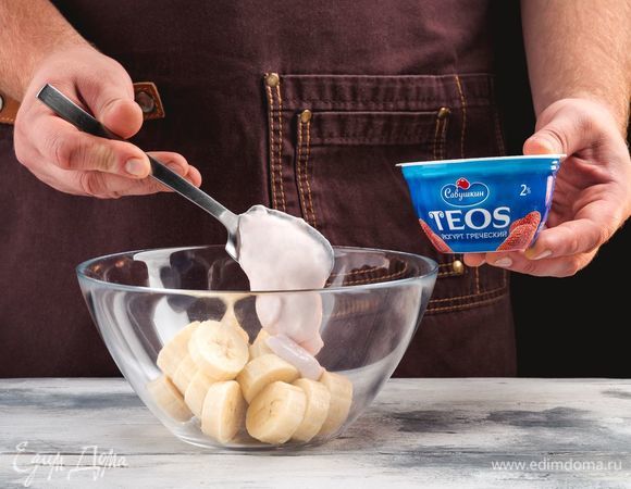 Выложите в миску бананы и греческий йогурт «TEOS» с клубникой. 
