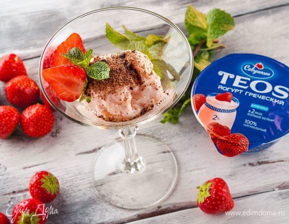 Выложите десерт по креманкам и украсьте ягодами клубники и шоколадной стружкой.