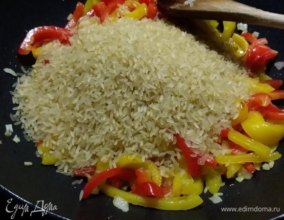 Добавить рис, перемешать ингредиенты и обжарить в течение 1 минуты, влить вино. Когда вино выпарится (а это происходит мгновенно), залить горячий бульон.