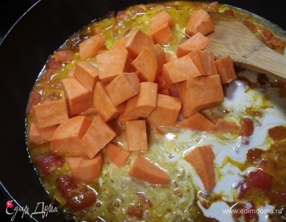 Влить кокосовое молоко и добавить батат, очищенный и нарезанный на кубики. Накрыть крышкой и тушить до готовности батата.