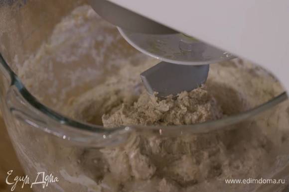 В 500 мл теплой воды всыпать соль, влить 4 ст. ложки оливкового масла, все перемешать и небольшими порциями влить в тесто, продолжая вымешивать на маленькой скорости.