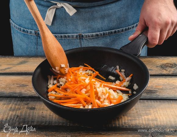 О<span>бжарьте в глубокой сковороде лук и морковь до прозрачности.</span>