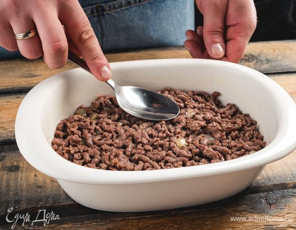 Ф<span>орму для запекания смажьте маслом. Выложите ровным слоем фарш.</span>