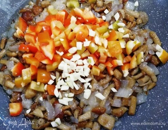 Добавляем болгарский перец, чеснок, солим и перчим. Обжариваем все вместе минут 5.