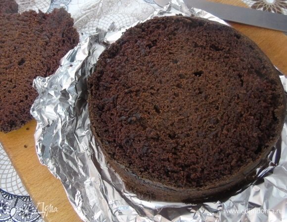 Верхушку бисквита срежьте и немного подсушите его в духовке. Бисквит разрежьте на два коржа. Я корж заворачиваю в пленку и оставляю на ночь в холодильнике — так структура у него становится лучше и он легче режется.