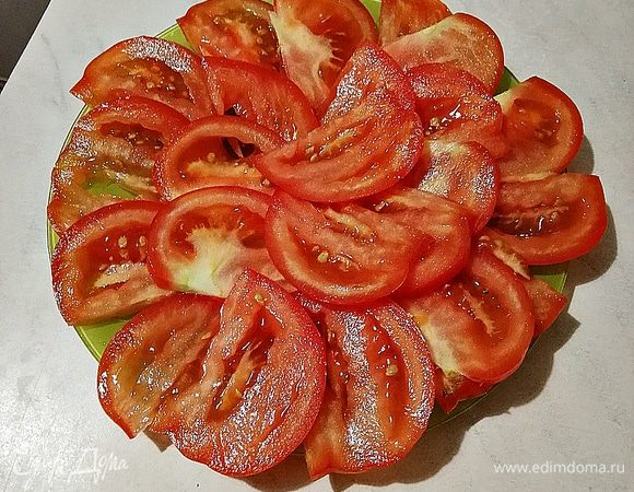 Помидор разрезаем на тонкие пластинки.