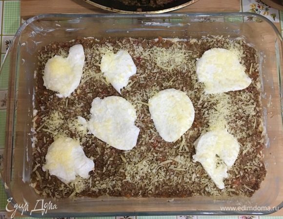 Затем положите кусочки моцареллы и посыпьте горстью пармезана. Повторите слои.