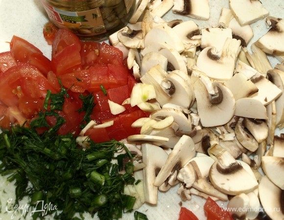 Помидоры бланшировать. Очистить кожицу и нарезать кубиками. Чеснок очистить, мелко порубить. Шампиньоны нарезать ломтиками. Зелень порубить.
