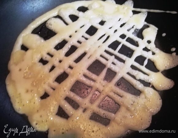 Тесто переливаем в бутылочку для соуса, произвольно наносим его на раскаленную сковороду и жарим блинчики с двух сторон.