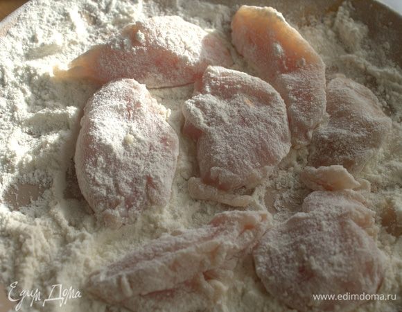 Обвалять кусочки курицы в муке.