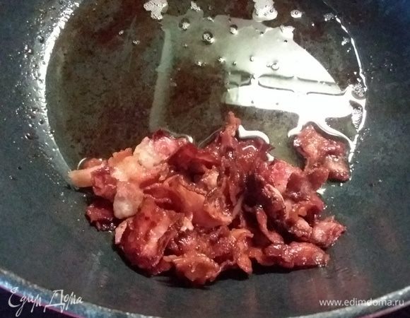 В кастрюле с толстым дном обжарить бекон, достать и выложить на бумажное полотенце.