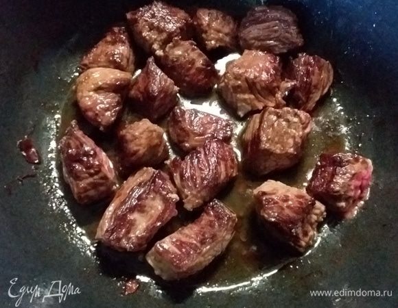 В этой же кастрюле обжарить мясо, нарезанное порционно, до золотистого цвета. Не все сразу, а частями, чтобы мясо не тушилось, а жарилось. Выложить мясо в тарелку, посолить и поперчить.
