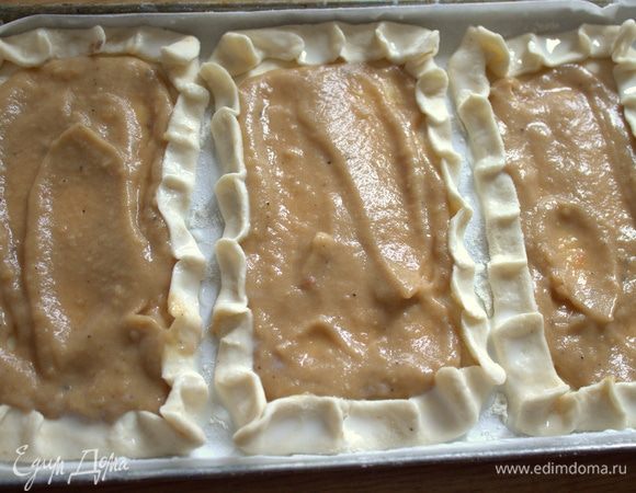 Перенести на поддон, застеленный пергаментом, посыпать мукой и заполнить первый слой соусом бешамель. Если его нет, просто смазать томатным или другим соусом.