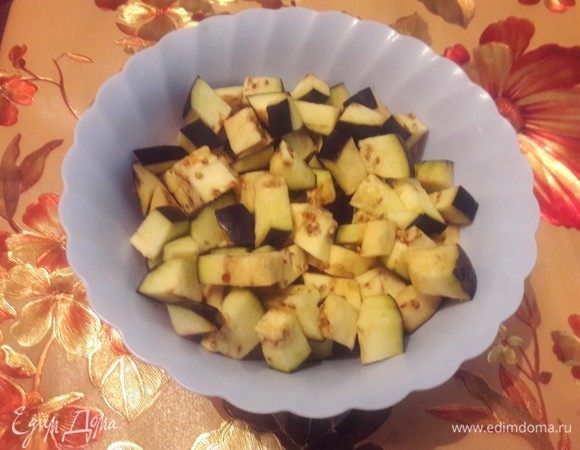 Для начала нужно мелко нарезать баклажаны кубиками, залить холодной водой с солью на 20 минут. Таким образом избавимся от горечи.