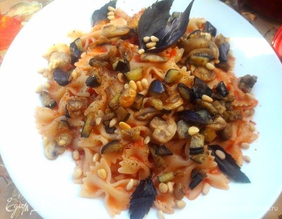 Готовые фарфалле полить томатным соусом, сверху выложить подготовленные ранее овощи, украсить кедровыми орешками и листьями базилика.