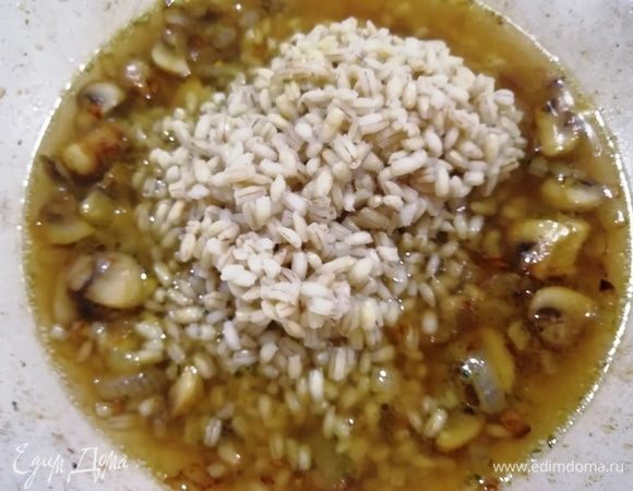 Добавляем к грибам перловку и треть стакана грибного бульона (можно добавить воду или вино). Помешивая, ждем, пока весь бульон не впитается.