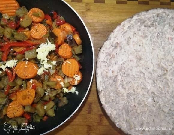 Куриный фарш утрамбовываем в форму для выпечки (у меня одноразовая), формируя бортики. К овощной основе добавляем измельченный чеснок и перемешиваем.