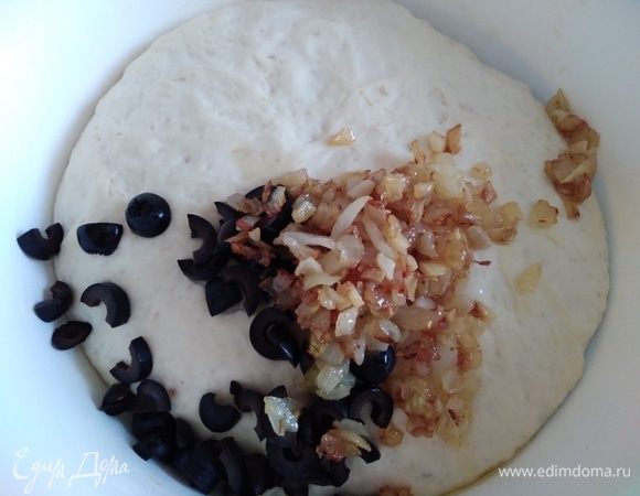 Добавить остывший лук и маслины. Вмешать в тесто.