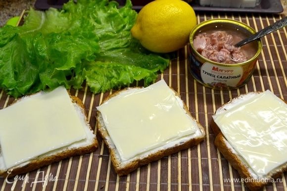 Первый слой хлеба смазать маслом, положить сверху плавленный сыр.