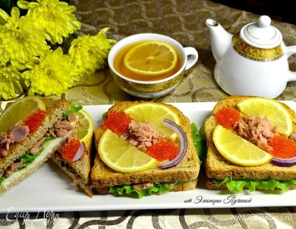 Далее кусок хлеба, обжаренный в тостере до золотистой корочки, и сверху на него красиво разложить дольки лимона и икру, в центр — кусочки тунца. Украсить кольцом красного лука.