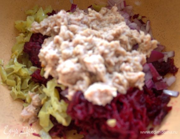 Добавить тунец без жидкости к свекле, предварительно размяв вилкой.