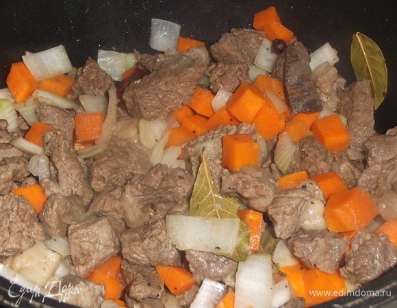 Засыпать нарезанный лук, лавровый лист, душистый и острый перцы. Перемешать, и тушить под крышкой еще 10 минут.