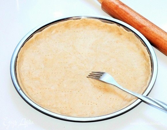 Раскатываем тесто на припыленной столешнице в круг (диаметр = 26 см) и при помощи скалки переносим в смазанную маслом формочку (диаметр = 26 см). Проткните тесто вилкой в нескольких местах.