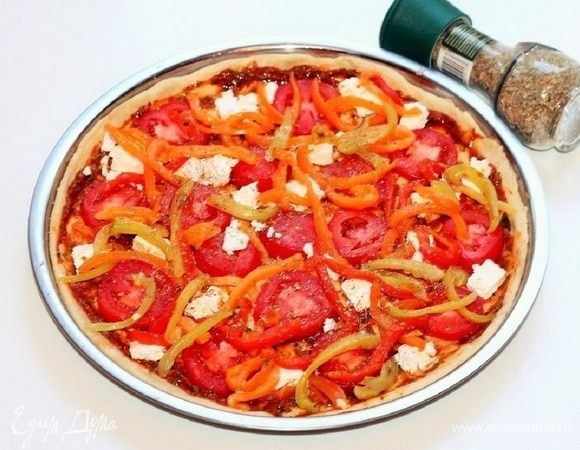 Сверху смазываем тесто чесночной заправкой (1 ст. л.) и раскладываем кружочки помидора, кусочки моцареллы и заправку с перцем. Посыпаем приправой. У меня смесь специй «Травы Италии».