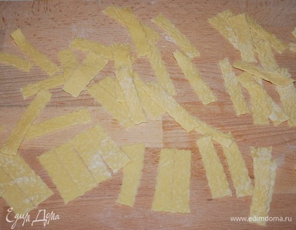 А квадраты разрезаем на 4 полоски. Пока работаем с одним пластом теста, другой убираем под пленку, чтобы оно не подсохло. Раскатывать сразу все не надо, иначе тесто подсохнет, и будет сложно крутить пасту.