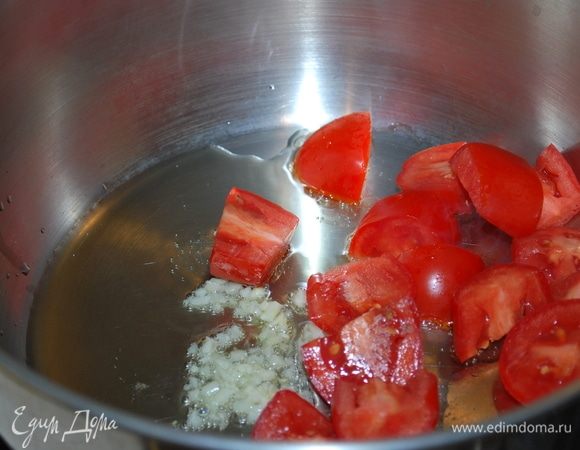 Нагреем масло в большой сковороде и обжарим чеснок, затем добавим помидоры, потушим пару минут.