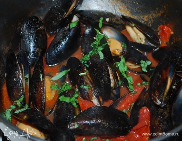 Теперь добавим очищенные и вымытые мидии, закроем сковороду крышкой и томим 5 минут. Потом добавим нарезанный базилик и проварим соус без крышки 4–5 минут.