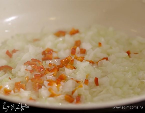 Разогреть в сковороде 1 ст. ложку оливкового масла и обжарить лук с перцем чили.