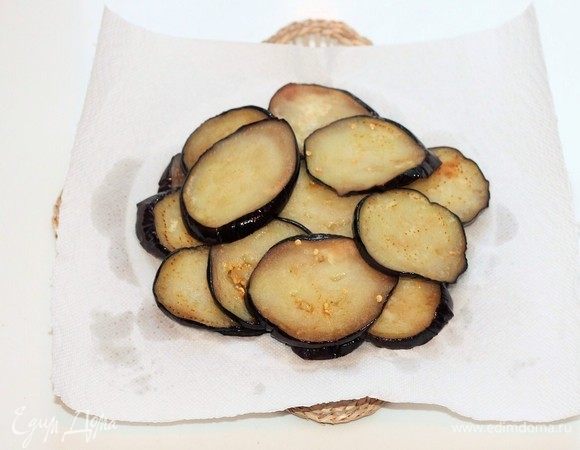 Обжарить кружочки баклажана на разогретом масле и выложить на бумажное полотенце, чтобы удалить излишки масла.