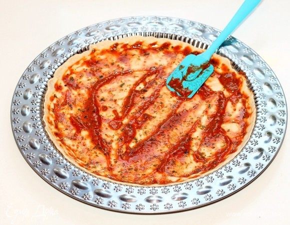 Смазать тесто острым чесночным соусом и разложить кружочки баклажана, кусочки моцареллы (или посыпать тертым пармезаном). Можно украсить пиццу полосками сладкого перца (без шкурки) и дольками помидора.