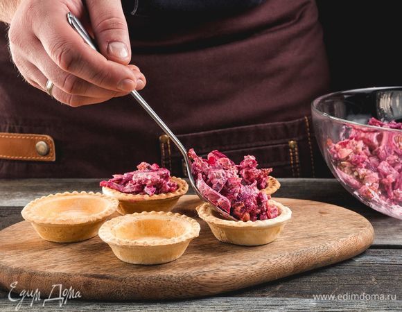 Разложите салат по тарталеткам. 