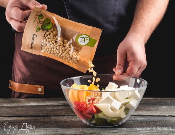 Смешайте фрукты и сыр, добавьте к ним кедровые орехи ТМ «Семушка» и листья шпината.