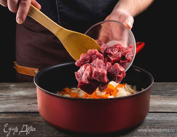 Крупно нарежьте говядину, выложите к овощам и подрумяньте со всех сторон.