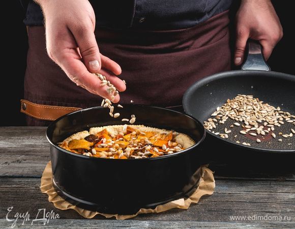 Выложите фруктовую начинку в песочную корзинку, посыпьте жареными семечками.