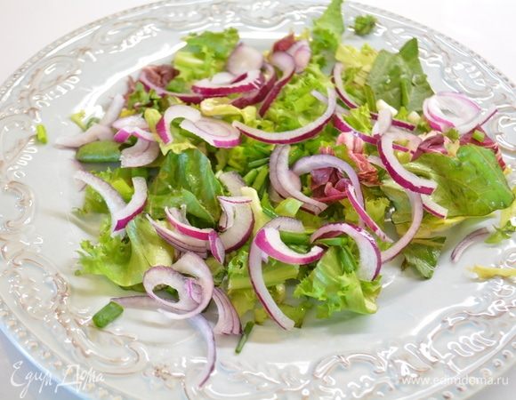 На блюдо выкладываем салатный микс и нарезанный полукольцами лук.