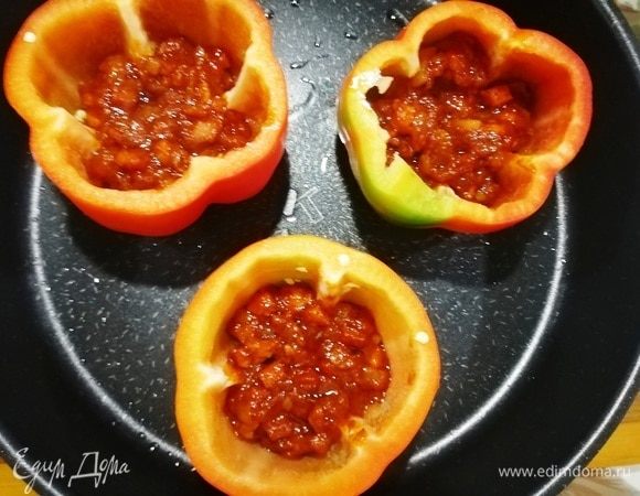 Срезаем верхушку болгарского перца и выкладываем в перец по 1 ст. л. томатного соуса.