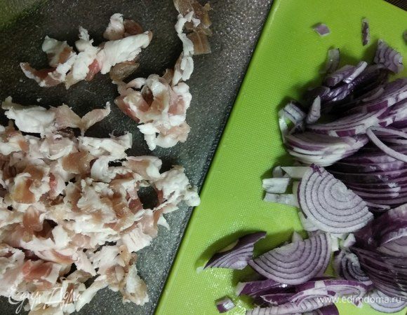 Бекон режем на кусочки, лук — полукольцами.
