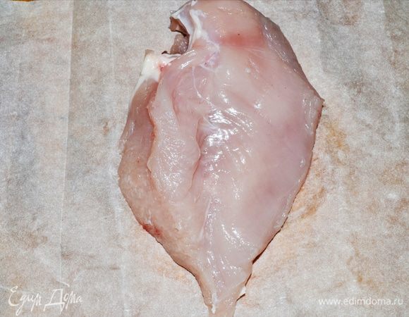 Пока соус уваривается, можно заняться нашей курочкой. Выкладываем филе на пергамент. Ножом вдоль по середине делаем надрез, как бы раскрывая филе, делая его плоским. Наша задача — сделать его одной толщины для правильной равномерной прожарки.