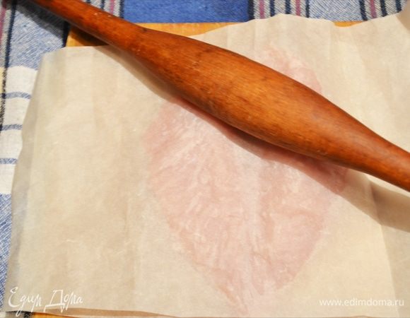 Накрываем грудку вторым листом пергамента. Берем скалку и начинаем как бы раскатывать филе осторожно, делая его равномерным по толщине.