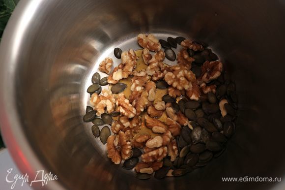 Поместить грецкие орехи (половинки, четвертинки ядер) и тыквенные семечки в сотейник с толстым дном.