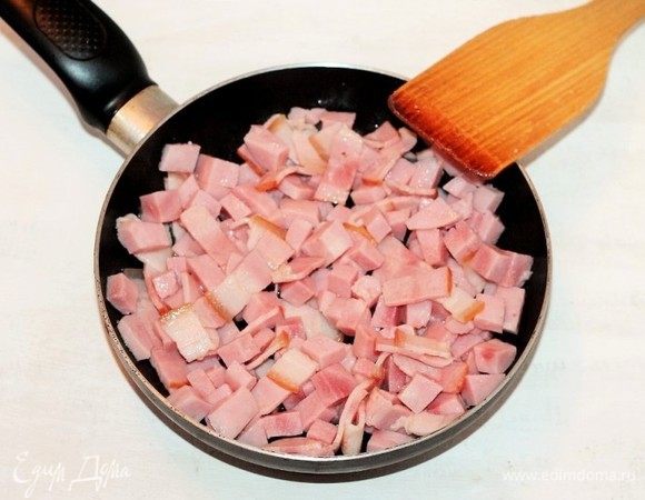 На разогретом растительном масле (1 ст. л.) обжариваем бекон с ветчиной.