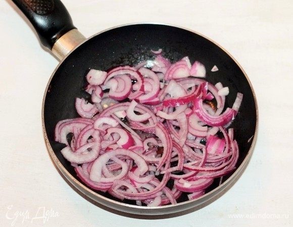 На чесночном масле обжариваем до прозрачности очищенный и нарезанный полукольцами красный лук.