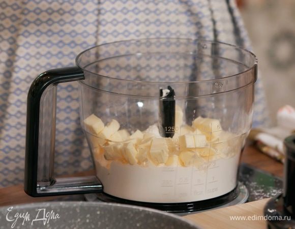 Приготовить тесто: 150 г предварительно охлажденного сливочного масла нарезать небольшими кубиками и вместе с мукой измельчить в блендере в крошку, затем посолить и еще немного взбить. Добавить желток и, продолжая взбивать, влить по одной 4 десертные ложки ледяной воды.