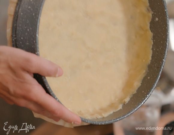 Дно разъемной формы выстелить бумагой для выпечки, смазать бумагу и стенки формы оставшимся сливочным маслом и тонким слоем выложить тесто, сформировав бортики.